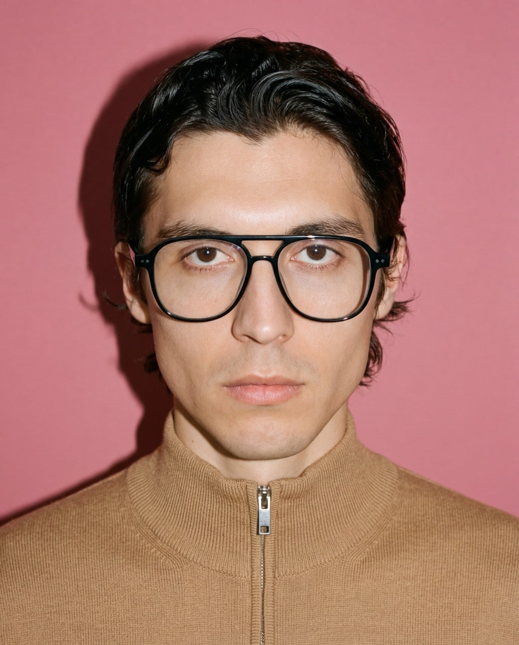 Junger Mann mit Pilotenbrille Faro mit Sehstärke im Aviator-Stil, schwarzes Acetat-Gestell mit Doppelsteg von Visiloox, frontal vor rosa Hintergrund